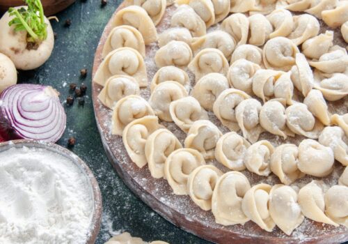 front-view-little-raw-dumplings-with-flour-dark-surface