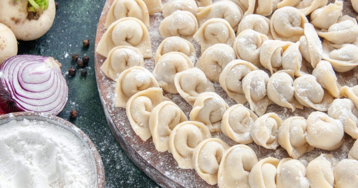 front-view-little-raw-dumplings-with-flour-dark-surface
